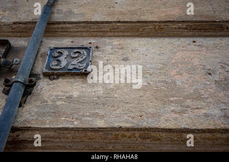 Old weathered rue en fonte avec plaque de numéro 32, trente-deux, couvert de peinture bleue éraflés au centre-ville de Sofia, Bulgarie dans moody automne nuageux da Banque D'Images