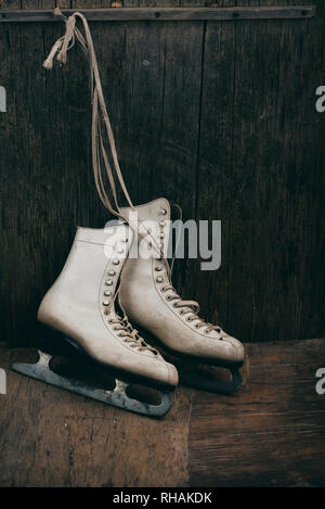 Maison de vacances hiver saison scène avec paire de patins à glace blanc sur fond de bois rustique avec copyspace. Banque D'Images