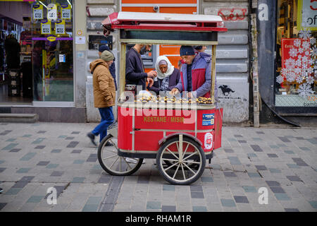 L'achat d'une femme marron les vendeurs de rue panier lors d'une froide journée de décembre. La vue du panier devant les magasins à Istanbul, Turquie. Banque D'Images