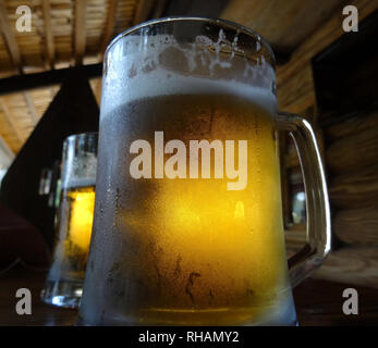 Deux pintes de bière artisanale sur la mousse avec le verre sur la table en bois Banque D'Images