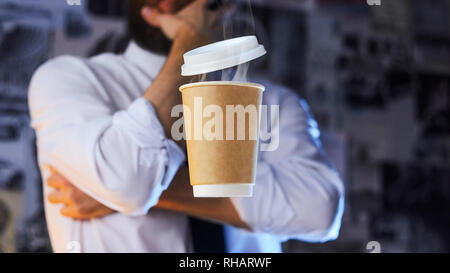 Barista méditative en chemise blanche et cravate et papier en lévitation tasse de café chaud. Arrière-plan de la publicité. Concept de placement de logo Banque D'Images