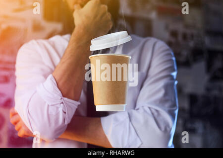 Barista méditative en chemise blanche et cravate et papier en lévitation tasse de café chaud. Arrière-plan de la publicité. Concept de placement de logo Banque D'Images