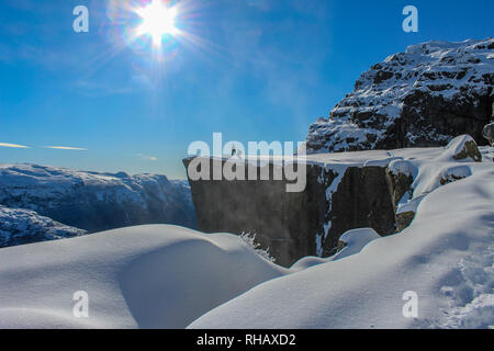 Deux personnes profitant du soleil sur Preikestolen en hiver, Stavanger, Norvège Banque D'Images