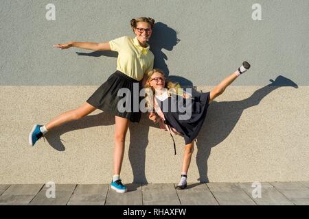 Cute sisters en uniforme d'écolière. Dans les verres, les filles vont à l'école, jouissant ensemble extérieur Banque D'Images