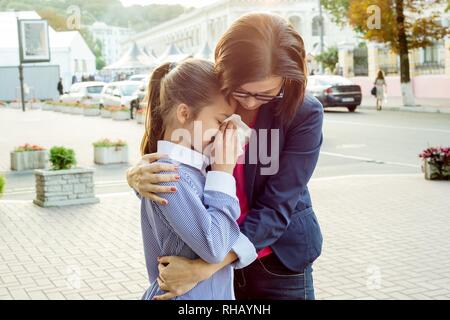 Ses pleurs consolant mère fille. Contexte urbain Banque D'Images