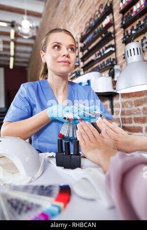Close-up of woman client choisir couleur de vernis à ongles dans un salon de manucure Banque D'Images