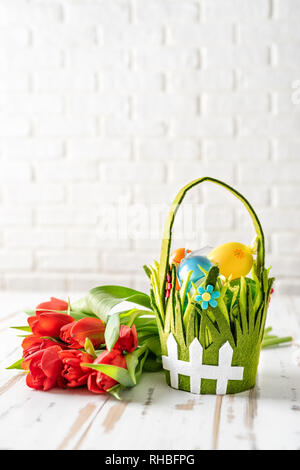 Shot vertical de la composition de pâques avec des tulipes blanches sur fond brique Banque D'Images