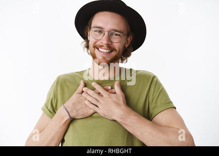 Oh merci vous n'aurait pas dû. Portrait de touché et heureux homme bday avec lunettes, Nez Percé et hat holding hands on body and smiling Banque D'Images