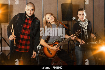 Groupe d'expression toung musiciens rock posant avec instruments en studio d'enregistrement Banque D'Images