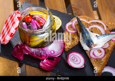 Des anchois marinés avec des oignons, betteraves, mélange de poivrons et de marinade au citron, vinaigre, huile d'olive et sel de mer. Servi sur pain noir à l'oignon Banque D'Images