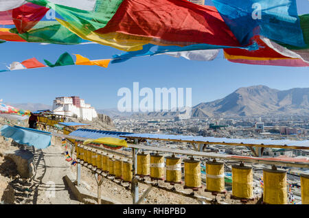 Samdruptse dzong encadrée par des roues de prière et les drapeaux de prières bouddhistes tibétains, Shigatse, Tibet Banque D'Images