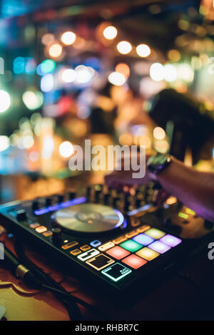 DJ joue live set et le mixage de la musique sur la console de la platine à l'étape de la boîte de nuit. Disc Jokey Mains sur un mixer de son club à la station de travail. DJ mixer Banque D'Images