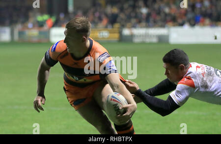 Castleford Tiger's Greg Eden (à gauche) est abordé par des Dragons Catalans David Mead au cours de la Super League à Betfred le Mend-A-tuyau Jungle, Castleford. Banque D'Images