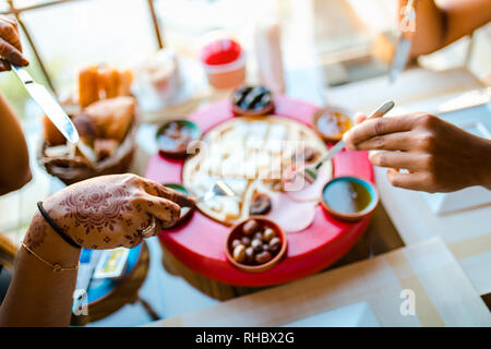 Jeune couple ayant les mains et manger de délicieux petit déjeuner village en Cappadoce en Turquie. L'henné ont fille dans sa main. Banque D'Images