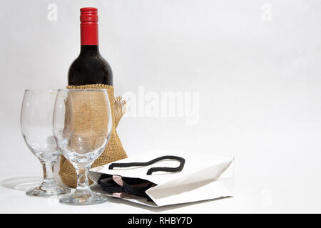 Bouteille de vin rouge, un blanc et deux wineglasses sac-cadeau. Anniversaire. Son anniversaire. Valentines Day. Banque D'Images