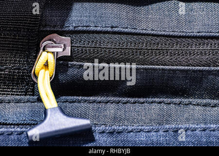 Close up sur fermeture éclair d'un sac de voyage avec cordon jaune et le plastique sur la fin Banque D'Images
