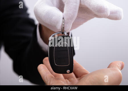 Close-up de la main de Valet donnant à l'homme clé de voiture Banque D'Images