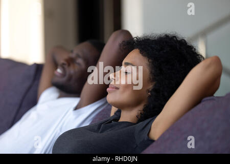 Couple africain détendue de respirer l'air frais sur un canapé confortable Banque D'Images