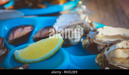 Plat d'huîtres et moules cuites et crues sur une table près de la mer dans le sud de la France Banque D'Images