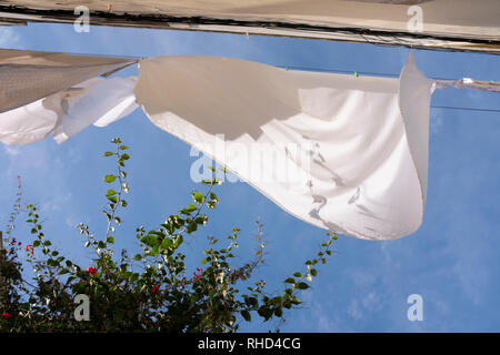 Les feuilles d'un blanc pur en train de sécher dehors par un jour de vent sur une ligne de lavage Banque D'Images