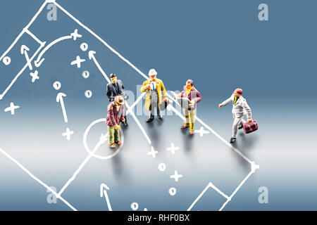 Groupe d'hommes d'affaires miniatures figurines standing ensemble et menant une discussion avec l'image du football footbal déposée auprès de jouer tactique et st Banque D'Images