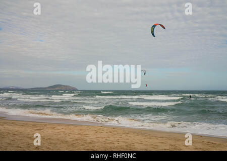 Vue pittoresque de la côte avec des kite surfeurs sur les vagues. Banque D'Images