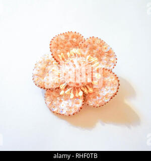 Broche pêche sous la forme d'une fleur de perles et paillettes. Banque D'Images