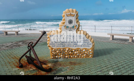 Une plaque en portugais décrivant la fière tradition maritime de la ville à côté d'une ancre rouillée, donnant sur l'Océan Atlantique Banque D'Images