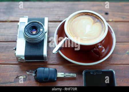 Vue supérieure de la tasse de café chaud , film appareil smartphone et sur la plaque de bois clé Banque D'Images