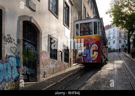 Les tramways de Lisbonne descendre une pente raide à côté de maisons traditionnelles Banque D'Images