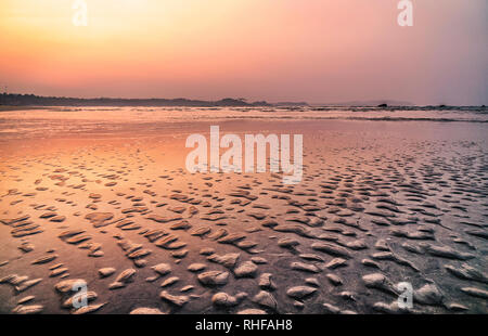 Coucher du soleil couleurs rose et violet dans une plage tropicale goa inde avec la texture du sable Banque D'Images