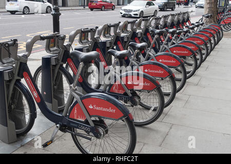 Londres, Royaume-Uni - 12 octobre 2018 : Santander rouge bordée d'un service de location de vélos et prêt à être embauchés dans les rues de Londres Banque D'Images