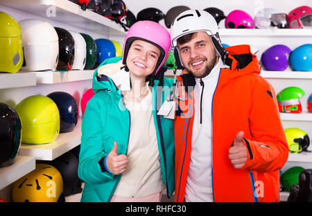 Happy young couple en tenue de ski satisfait de choix en magasin moderne d'équipement sportif Banque D'Images