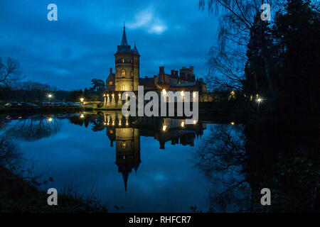 La spectaculaire tour en stuc reflété dans le lac immobilier Immobilier à Horsley Towers dans le Surrey au crépuscule Banque D'Images