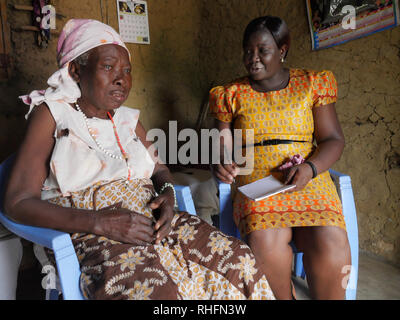 KENYA Mombasa, le bidonville du Bangladesh. Caroline Osong, travailleur social de la clinique Bangladesh visiter des patients à leur domicile. Ici la visite 79-year-old Rose Muyuka, grand-mère qui a perdu ses enfants à cause du SIDA. Rose souffre de diabète et est partiellement aveugles. Banque D'Images