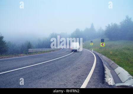 Deux cvered Alpine lane road dans un épais brouillard Banque D'Images