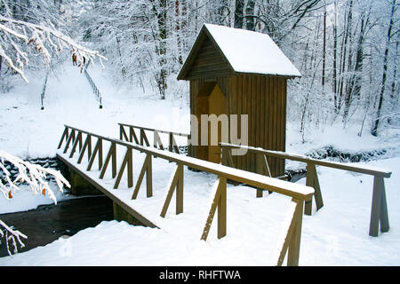 Pont de bois et chalet dans une forêt en hiver avec des arbres couverts de neige Banque D'Images