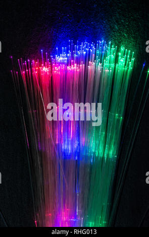 Fibres optiques colorés illuminé sur fond sombre. Internet haute vitesse gratuit. Transfert de données câble optique. Bande de beaucoup de fibres optiques, glo Banque D'Images