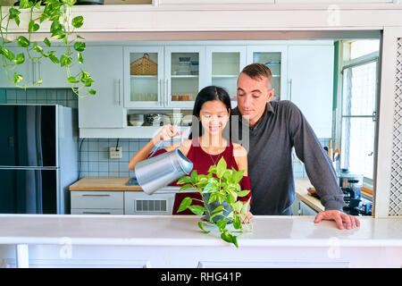 Quel beau couple posing - arrosage des plantes et prendre soin des plantes Banque D'Images