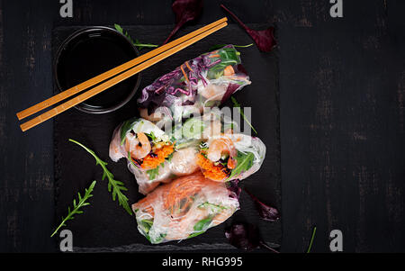 Végétarien vietnamien des rouleaux de printemps avec crevettes épicées, les crevettes, les carottes, le concombre, le chou rouge et le riz et nouilles. Les fruits de mer. Repas savoureux. Vue de dessus, la télévision Banque D'Images