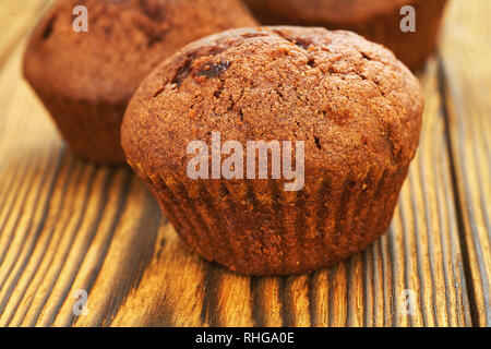 Muffin au chocolat avec fond sombre test sur une vieille table en bois. Banque D'Images