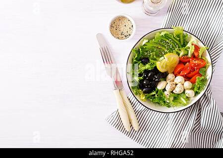 Salade fraîche avec de l'avocat, tomate, olives et mozzarella dans un bol. Bol Bouddha. Alimentaire de remise en forme. Repas végétarien. Vue d'en haut Banque D'Images