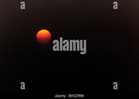 Le soleil capturées à l'aide d'un filtre, montrant les nuages passant dans front​ d'un soleil orange Banque D'Images