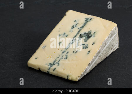 Un morceau de fromage en provenance d'Affine Montagnolo Bavière, Allemagne fabriqué à partir de lait de vache, photographié sur un fond foncé, ardoise. England UK GO Banque D'Images