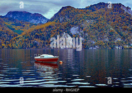 Magnifique coucher de soleil sur le pittoresque lac Alpes autrichiennes. Bateaux, yachts dans la lumière du soleil en face de l'église sur le rocher avec des nuages plus de Traunstein montagne à t Banque D'Images