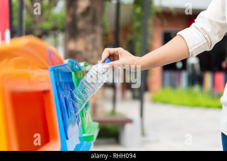 Closeup portrait woman throwing vide bouteille d'eau en plastique dans le bac de recyclage. Banque D'Images