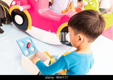 Des enfants jouent des pièces en bois. Banque D'Images