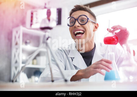 Cheerful student wearing glasses sentiment très émotionnel faire expérimenter Banque D'Images