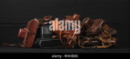 Tas de 35mm appareils anciens en cuir, fond noir. Collection et les ventes aux enchères Banque D'Images