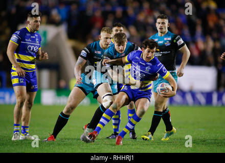 Cheshire, Royaume-Uni. Feb 2019 2ème. Betfred Super League Warrington Wolves v Leeds Rhinos Stefan Ratchford de Warrington Wolves abordés par Mikolaj Oledzki et Liam Sutcliffe de Leeds Rhinos. Credit : Touchlinepics/Alamy Live News Banque D'Images